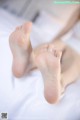 A close up of a person's feet on a bed.