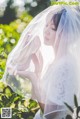 A woman in a wedding dress with a veil over her head.