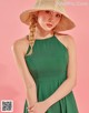 A woman in a green dress and a straw hat.