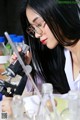 A woman in a lab coat looking through a microscope.