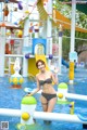 A woman in a bikini standing in a water park.