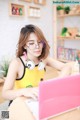 A woman sitting at a table with a laptop and headphones on.