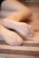 A close up of a person's feet on a carpeted floor.