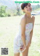 A woman in a white dress standing in a field.