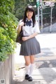 A woman in a school uniform is posing for a picture.