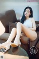 a woman sitting on top of a couch next to a table